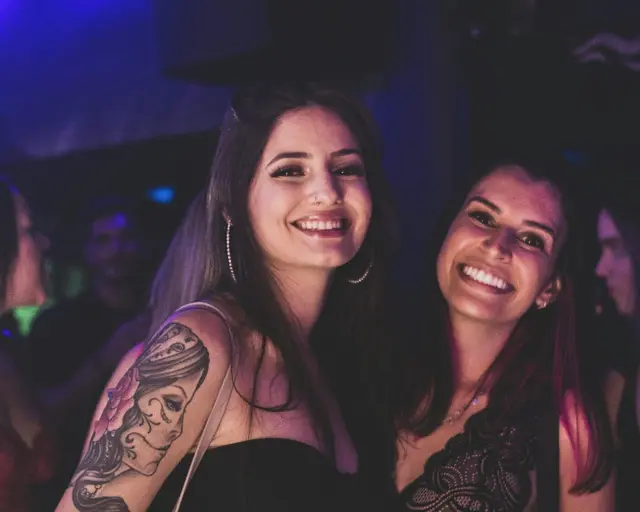 Two women laughing and celebrating at a Latin party